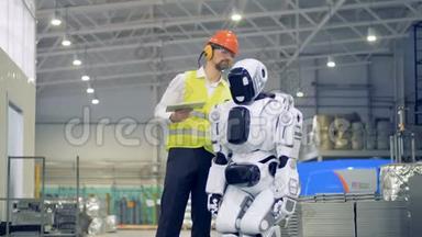 男工打<strong>开机</strong>器人，然后在工厂里迎接它。 4K.
